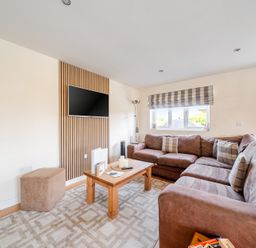 A living room with a sofa and television at James Ville Marina Lodge 7 in Brigg