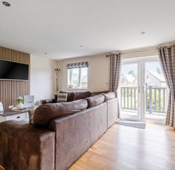 A living room with a sofa and television at James Ville Marina Lodge 8 in Brigg