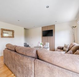 A living room with a sofa and television at James Ville Marina Lodge 8 in Brigg