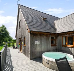 An outdoor area with a hot tub and wooden decking at James Ville Marina Lodge 13 in Brigg