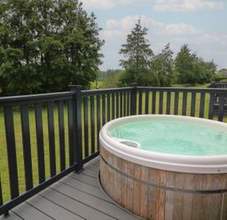 An outdoor area with a hot tub on a deck at James Ville Marina Lodge 14 in Brigg