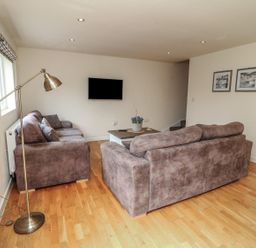 A living room with a television, sofa, and lamp at James Ville Marina Lodge 14 in Brigg