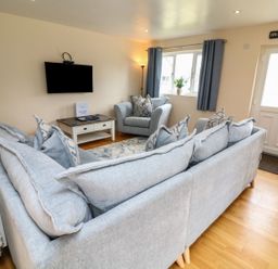 A living room with a sofa and television at James Ville Marina Lodge 21 in Brigg