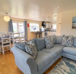A living room with a sofa and dining area at James Ville Marina Lodge 21 in Brigg