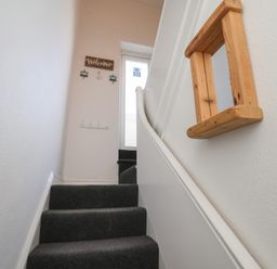 A staircase with a door and a welcome sign at Apartment 3 in Scarborough