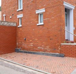 An outdoor area with a brick wall and a door at 16 Elmbank Gardens Paignton