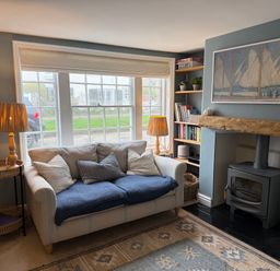 A living room with a sofa and fireplace at York Cottage in Southwold