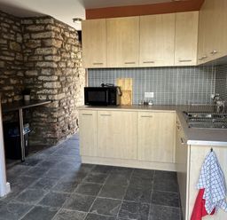 A kitchen with cabinets and a microwave at Coach House near St Clears