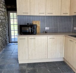 A kitchen with cabinets and a microwave at Coach House near St Clears
