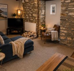 A living room with a television and sofa at Coach House in St Clears