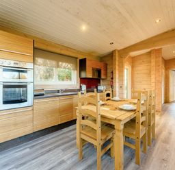 A kitchen with wooden furniture and appliances at Poplar Lodge (Pet) Thirsk