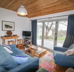 A living room with a sofa and television at The Faithfuls Cabin in Dingle