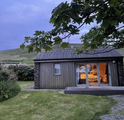 A cabin with a large window and door in Dingle, County Kerry