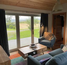 A living room with a sofa and armchair at The Faithfuls Cabin in Dingle, County Kerry