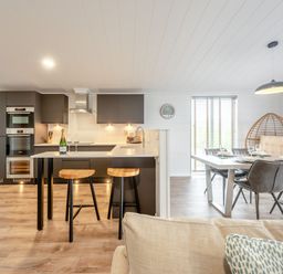 A kitchen with an island and dining area at Sonnet 3 Spa in Carmarthen