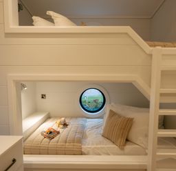 A bedroom with bunk beds and a round window at Wansfell (Pet) Penrith