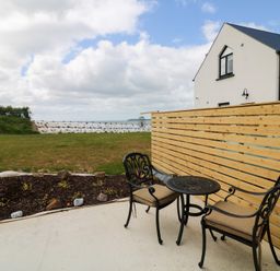 A garden area with a table and chairs at Radharc an Hook @ Estuary Bliss