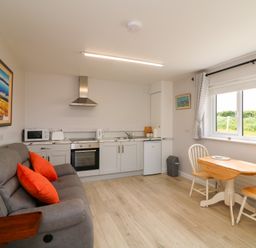 A kitchen with a sofa and dining table at Radharc an Hook @ Estuary Bliss