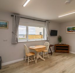 A dining room with a table and chairs at Radharc an Hook @ Estuary Bliss