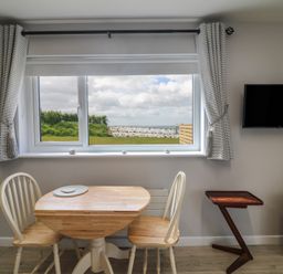 A dining room with a table and chairs at Radharc an Hook @ Estuary Bliss