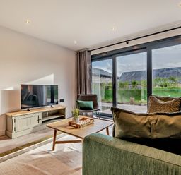 A living room with a television, sofa, and coffee table at Arvor Wetroom Studio 1.0
