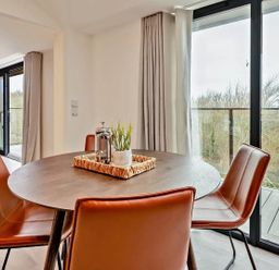 A dining room with a round table and chairs at Whalesborough Penthouse 2.0 in Marhamchurch
