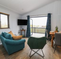 A living room with a sofa and dining table at Grass Roots