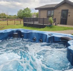 A hot tub with bubbles in an outdoor area at Grass Roots in Henstridge near Stalbridge