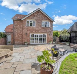 A brick house with a patio and garden at Oldfields in Bury St Edmunds