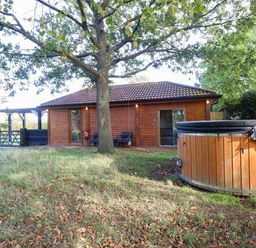 An outdoor area featuring a cabin and hot tub at Oldfields Bury St Edmunds
