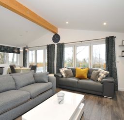A living room with a gray sofa and white table at 20 Meadow Retreat in Dobwalls