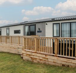 A cabin exterior with a deck and steps at Willow's Way in Stranraer