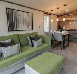 A living room with a sofa and dining area at Willow's Way in Stranraer