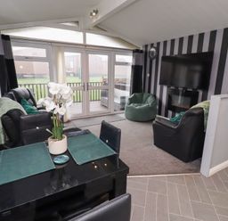 A living room with a sofa and dining table at Harper's Hideaway near Felmoor Holiday Park near Felton