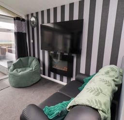 A living room with a television and a bean bag at Harper's Hideaway, Felmoor Holiday Park near Felton