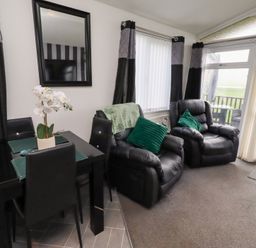 A living room with a dining table and chairs at Harper's Hideaway near Felmoor Holiday Park