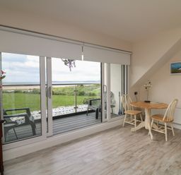 A dining area with a table and chairs at Ard Uisce @ Estuary Bliss, Duncannon, County Wexford