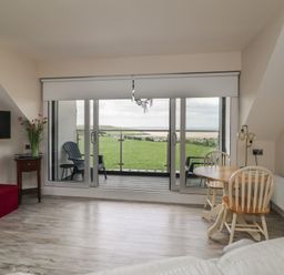 A living room with a television and dining table at Ard Uisce @ Estuary Bliss Duncannon, County Wexford