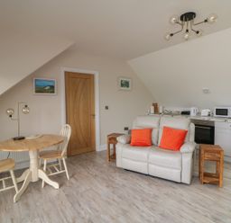 A living room with a sofa and dining table at Ard Uisce @ Estuary Bliss, Duncannon, County Wexford