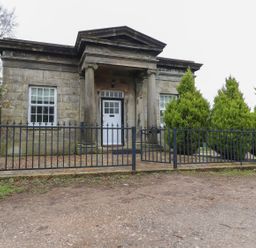 A building with a fence and trees at The Lodge House in Dolphinholme near Galgate
