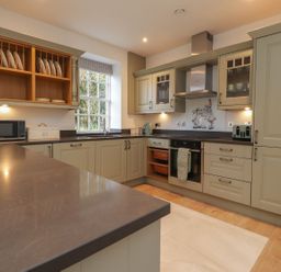 A kitchen with cabinets and appliances at The Lodge House in Dolphinholme near Galgate
