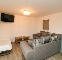A living room with a sofa and television at Tooth Suite Yarm