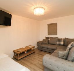 A living room with a sofa and television at Tooth Suite in Yarm