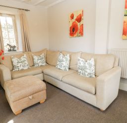 A living room with a sofa and cushions at The Smithy in Stow on the wold