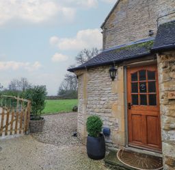 An exterior view of The Smithy with a door and sign in Stow-On-The-Wold