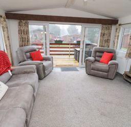 A living room with sofas and a television at Chloe's Cabin near Felmoor Holiday Park near Felton