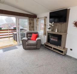 A living room with a recliner chair and television at Chloe's Cabin Felmoor Holiday Park near Felton
