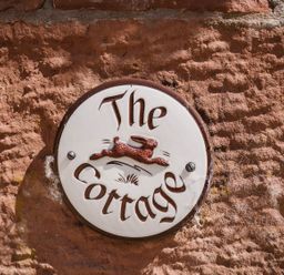A sign that reads 'The Cottage' on a wall at Carwinley Mill House Cottage near Longtown