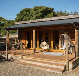 An outdoor area with wooden cabin and seating at The Chard in Carlisle
