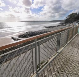 A balcony overlooking the ocean and beach at Rock House in Narberth
